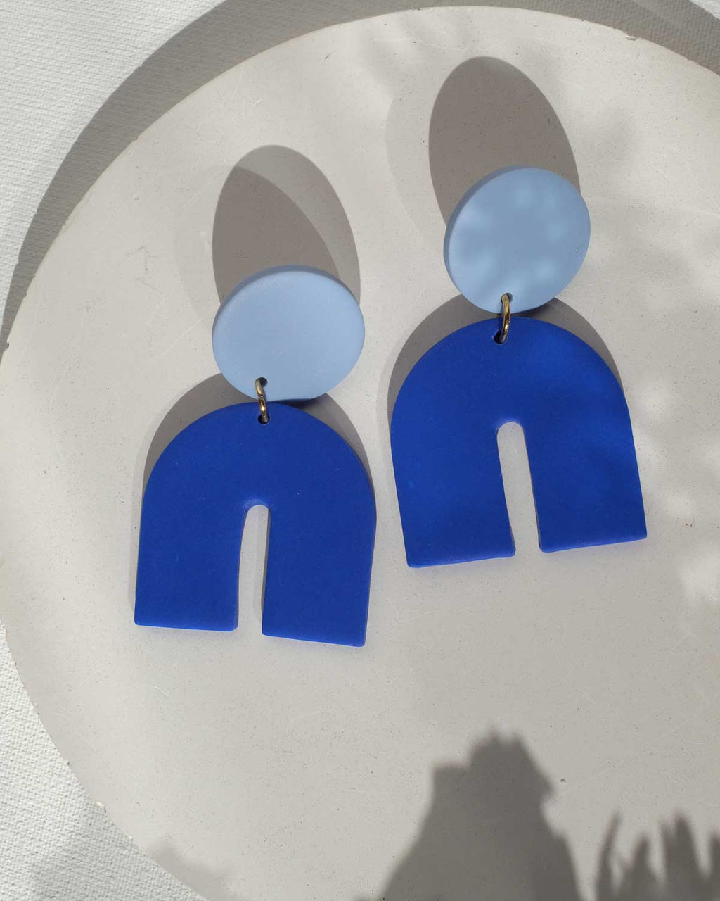 Bogenförmige Ohrringe in Blautönen