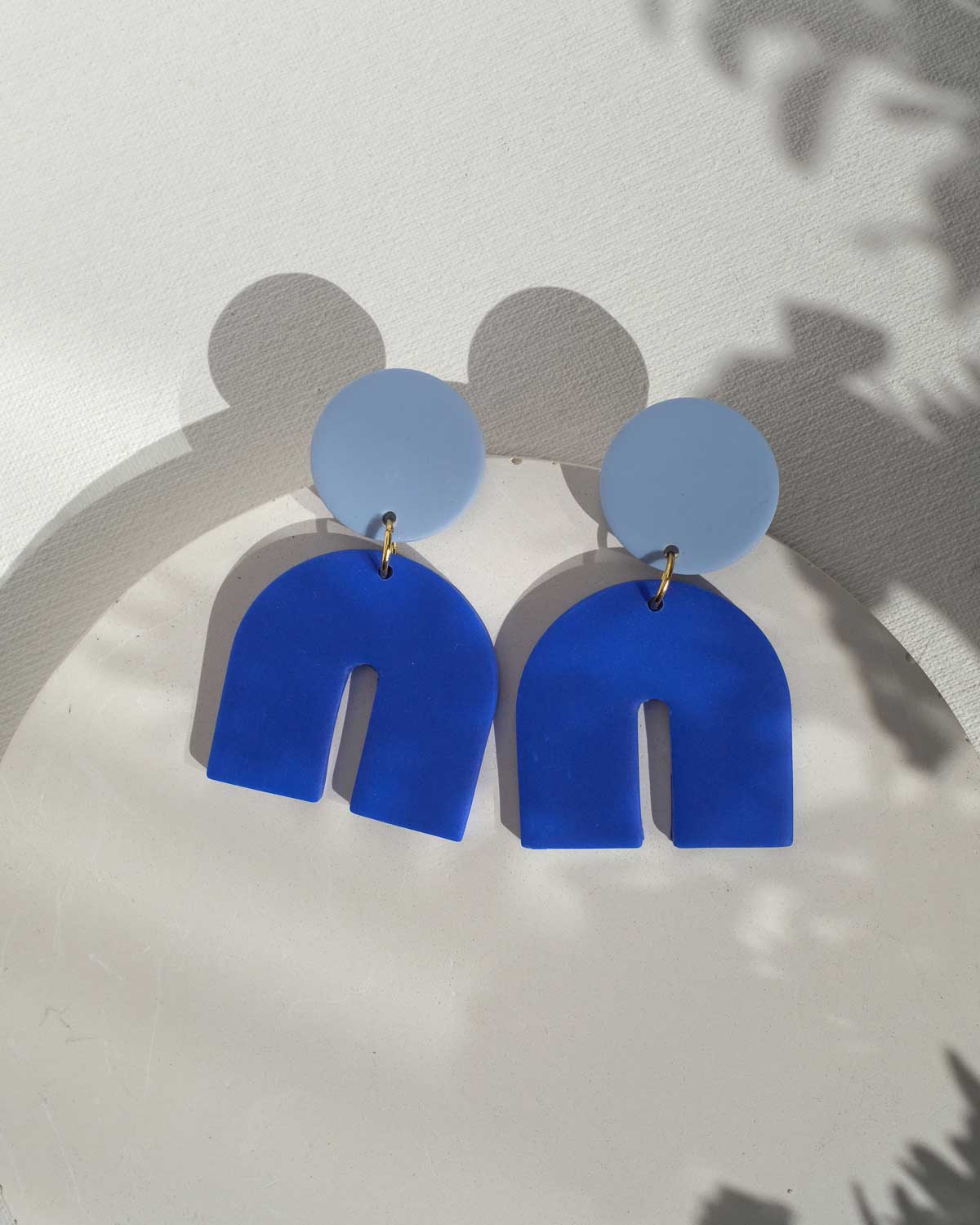 Bogenförmige Ohrringe in Blautönen